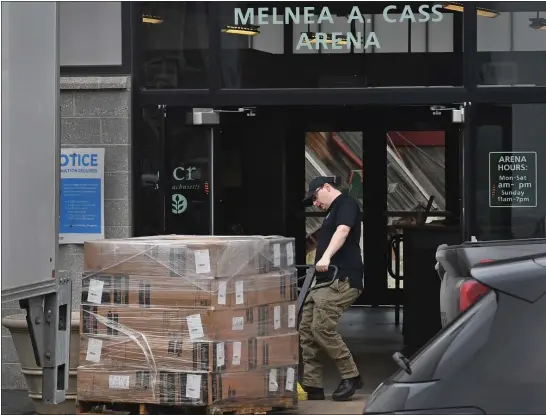  ?? CHRIS CHRISTO — BOSTON HERALD ?? A person unloads supplies for children from a Massachuse­tts Emergency Management Agency truck to stock the Melnea Cass Recreation Center to shelter migrants.