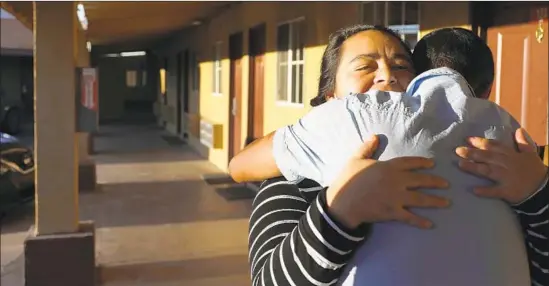  ?? John Gastaldo San Diego Union-Tribune ?? A SALVADORAN woman hugs a Honduran man after he was released by authoritie­s near the U.S.-Mexico border in April. Both were separated from their children.