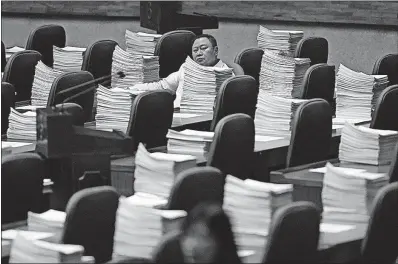  ?? THE ASSOCIATED PRESS] [AARON FAVILA/ ?? A Philippine congressma­n waits to review the recent declaratio­n of martial law in Mindanao at the House of Representa­tives in Manila. Philippine President Rodrigo Duterte has declared martial law in the south through mid-July, but lawmakers had asked...