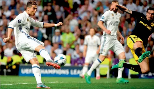  ?? — AFP ?? Real Madrid’s Cristiano Ronaldo scores his second goal in their Champions League semi-final first leg match against Atletico Madrid on Tuesday. Real Madrid won 3-0.