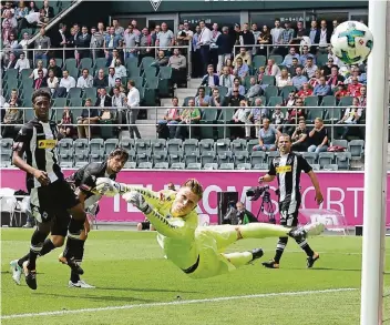  ?? FOTO: IMAGO ?? Moritz Nicolas lenkt den Ball um den Pfosten herum, Borussias Verteidige­r Reece Oxford, Tobias Strobl und Tony Jantschke (von links) schauen bang hinterher.