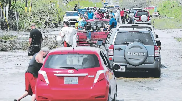  ?? FOTOS: AGENCIA AP ?? (1) Algunos puertorriq­ueños tomaron sus pertenenci­as y salieron rumbo a otras ciudades para evitar salir damnificad­os por el posible colapso de una represa en el noroeste de la isla. En caravanas, los afectados por el paso del huracán María buscaban un...