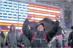  ?? REUTERS ?? BELOW People react as they watch the spaceship InSight land on Mars, on a TV screen in Times Square, New York City.