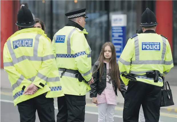  ?? OLI SCARFF / AFP / GETTY IMAGES ?? Police talk to people Tuesday affected by the deadly terror attack at Manchester Arena in Manchester, England, on Monday night.