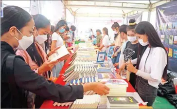  ?? MENEA HONG ?? Young people buying books at the 9th Cambodia Book Fair held at National Library on December 11.
