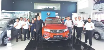  ??  ?? Ahmadi (fourth right), KH Motor director Wong Park Sii (seventh left) and the KH Motor sales team pose with the new Proton X70 during its unveiling at their centre yesterday.