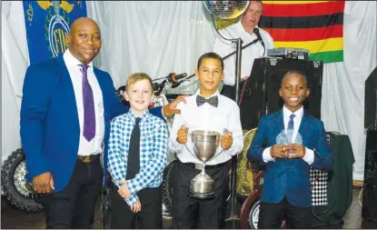  ??  ?? WINNERS PODIUM . . . Local junior motocross sensation Daiyaan Manuel (second from right), the 2017 National 65cc Class Champion, and his runner-up Emmanuel Bako (right) proudly display their trophies in the presence of the latter’s father and manager...