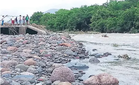  ??  ?? AFECTADOS. La fuerte correntada de agua en el río Orocuina dañó el puente bailey que comunicaba a Apacilagua con Orocuina.