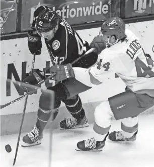  ?? JAY LAPRETE/AP ?? The Blue Jackets’ Alexandre Texier, left, and the Red Wings’ Christian Djoos chase a loose puck during the first period Tuesday, in Columbus, Ohio.