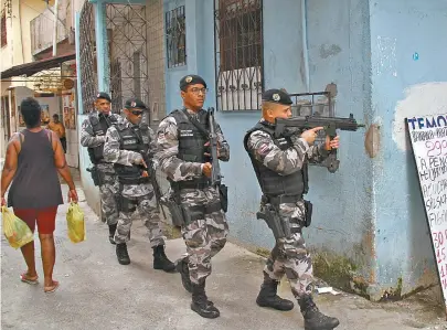  ??  ?? Policiais da Patamo circulam armados por ruas do bairro: dois foram presos por tráfico de drogas