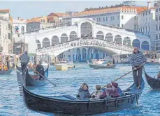  ?? FOTO: DPA ?? Protestban­ner mit dem Wort „Venexodus“an der Rialtobrüc­ke: Die Bewohner von Venedig wehren sich gegen die vielen Touristen.