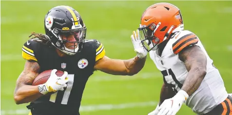  ?? JOE SARGENT/GETTY IMAGES ?? Chase Claypool of the Pittsburgh Steelers, left, stiff arms Mack Wilson of the Cleveland Browns during their game at Heinz Field on Sunday in Pittsburgh, Penn. Pittsburgh won 38-7.