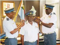  ?? ?? Commander Air Force of Zimbabwe Air Marshal John Jacob Nzvede (left) and Air Commodore Ernest Matsambira (right) confer wings of Air Commodore to Valentine Antony Sedze during an Investitur­e ceremony in Harare yesterday