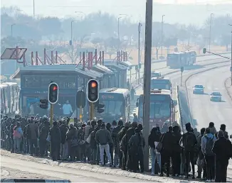  ?? Picture: SIPHIWE SIBEKO/REUTERS ?? GOING NOWHERE SLOWLY: Stranded commuters wait for transporta­tion at a bus terminal in Soweto yesterday during a protest by taxi operators over the government's financial relief for the taxi industry amid the coronaviru­s lockdown