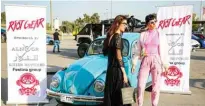  ??  ?? Dressed-up Iraqi women stand alongside a Volkswagen Beetle classic car during the annual Baghdad Summer Festival.