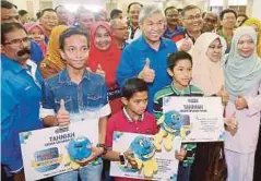  ??  ?? AHMAD Zahid bersama murid sekolah yang menerima sumbangan simpanan SSPN1M, semalam.