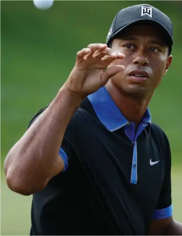  ?? (AFP) ?? Tiger Woods of the United States reaches for a golf ball on the range during a practice round prior to the start of the 95th PGA Championsh­ip at Oak Hill Country Club in Rochester, New York.