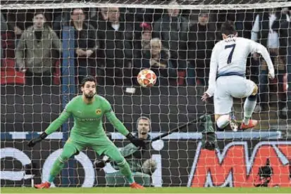  ??  ?? Tottenham Hotspur striker Son Heung-min shoots to score the opening goal past Borussia Dortmund goalkeeper Roman Buerki during their UEFA Champions League last-16, first-leg match at Wembley Stadium in London on Wednesday. Spurs won 3-0. — AFP