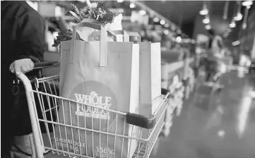  ??  ?? Bags of groceries sit in a shopping cart at a Whole Foods Market Inc. store in Dublin, Ohio, on Nov 7, 2014. — WP-Bloomberg photo