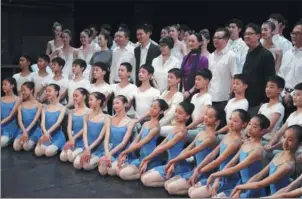  ??  ?? Teachers and students from the dance school affiliated with the National Ballet of China pose for a group photo at a news conference for the 60th anniversar­y of the company on Sept 19 in Beijing.