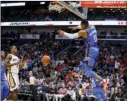  ?? SCOTT THRELKELD — THE ASSOCIATED PRESS ?? Oklahoma City Thunder’s Russell Westbrook (0) dunks as New Orleans Pelicans guard Rajon Rondo (9) trails the play in the first half of an NBA basketball game in New Orleans Monday.