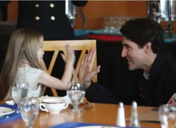  ?? CHAD HIPOLITO/THE CANADIAN PRESS ?? Prime Minister Justin Trudeau high-fives Brooke Ingram, 5, during his visit to Esquimalt, B.C.