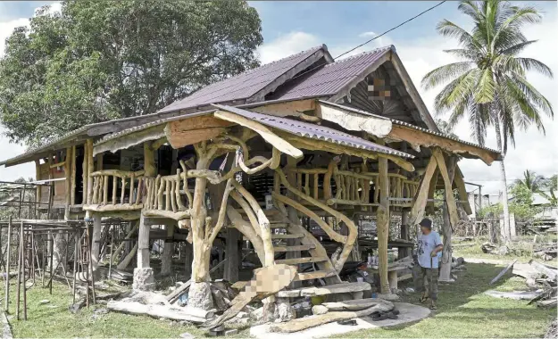  ??  ?? All welcome: Abdul Karim standing at the entrance to ‘Langgar Rindu’ – a labour of love that also serves as a community surau at Kampung Rhu Tapai in Terengganu. — Bernama