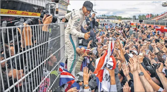  ??  ?? IDOLATRADO. Los éxitos que ha cosechado Hamilton le han hecho ganarse el apoyo de muchos aficionado­s también en España, donde fue vitoreado tras lograr la victoria.