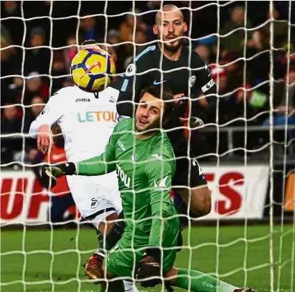  ?? — AFP ?? Silva lining: Manchester City’s David Silva (centre) scoring one of his two goals against Swansea during the English Premier League match at the Liberty Stadium on Wednesday.