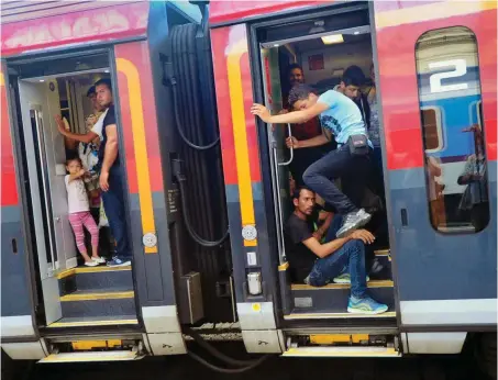  ?? Foto: AFP/Attila Kisbenedek ?? Diese Flüchtling­e haben es in den Zug geschafft, der sie von Budapest nach München bringen sollte – doch nicht alle kamen an.