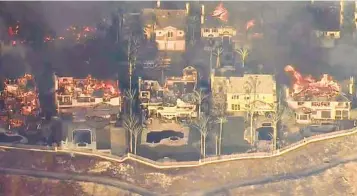  ?? KTLA ?? Homes burn in the Coronado Pointe community in Laguna Niguel Wednesday as the Coastal fire spread.