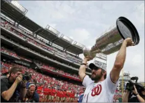  ?? ALEX BRANDON — THE ASSOCIATED PRESS ?? Washington Capitals’ Alex Ovechkin, from Russia, lifts the Stanley Cup on the field before a baseball game between the Washington Nationals and the San Francisco Giants at Nationals Park, Saturday in Washington.