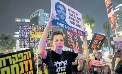  ?? ?? Clamor. Una mujer alza la foto de uno de los rehenes en manos de Hamas durante una marcha en Tel Aviv.RTR