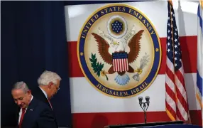  ?? (Reuters) ?? PRIME MINISTER Benjamin Netanyahu walks past US Ambassador to Israel David Friedman during the dedication ceremony of the new US embassy in Jerusalem Monday.