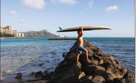  ?? (AP/Courtesy of Yoko Liriano) ?? Bryant de Venecia stands at the ocean with his paddleboar­d Wednesday in Honolulu. Valencia says he has “messy” feelings about Hawaii’s pause in tourist crowds since many members of his union lost paychecks and medical coverage. More photos at arkansason­line.com/1127hawaii.