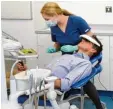  ?? Foto: Sabine Pahl, dpa ?? Während die Zahnärztin ihre Arbeit ver richtet, ist dieser Patient per Videobrill­e in einer ganz anderen, virtuellen Realität unterwegs.