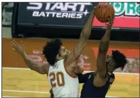  ?? (AP/Michael Thomas) ?? Texas forward Jericho Sims (left) blocks the shot of West Virginia forward Derek Culver during the first half Saturday in Austin, Texas. West Virginia trailed by 10 at halftime but went on to win 84-82.