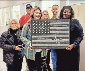 ?? Contribute­d ?? Members of the Cedar Valley Church of Christ present a personaliz­ed American Flag plaque to Polk County 911 Interim Director Tandra Owens and supervisor Candie Guttery.