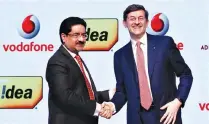  ??  ?? KUMAR MANGALAM BIRLA (L), chairman of Aditya Birla Group, shakes hands with Vittorio Colao, CEO of Vodafone Group, after a news conference in Mumbai, India March 20.