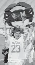  ?? KARL MERTON FERRON/BALTIMORE SUN ?? Maryland’s Adam DiMillo hoists the rivalry trophy in College Park. The Terps scored the first eight goals on the way to an easy win over Johns Hopkins.