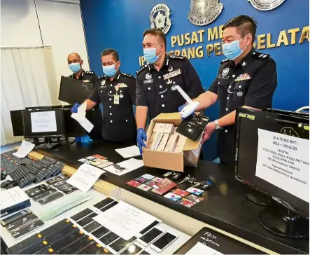  ??  ?? Tools of the trade: Sahabudin (second from right) and South Seberang Prai OCPD Supt Lee Chong Chern (right) with some of the items used by online gambling syndicates to conduct their illegal businesses, which had been seized in three operations across Penang. — LO TERN CHERN/The Star