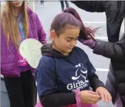  ?? ?? Lilliana Cardona-Leinbach gets some purple spray and pink glitter on her hair in preparatio­n for Nov. 13’s Girls on the Run 5K at Penn State Berks.