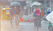  ?? SANCHIT KHANNA/HT PHOTO ?? People walk with umbrellas amid heavy showers near Jama Masjid in New Delhi on Sunday.