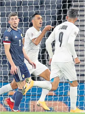  ??  ?? Above left: Ryan Christie slots home the penalty to give Scotland the lead late in the first half; above right: Eran Zahavi celebrates after scoring Israel’s equaliser; left: John McGinn tries to find a way past Hatem Elhamed; right: Christie wins an aerial duel with Israel captain Bibras Natcho.