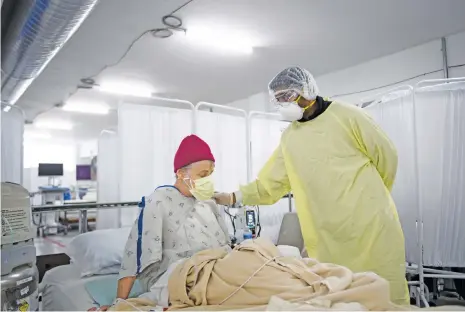  ?? Picture: AFP ?? FAMILIAR SIGHT. Dr Bĳay Sah attends to a patient in the Covid-19 alternativ­e care site, built into a parking garage, at Renown Regional Medical Center in Reno, Nevada, last month. The United States has recorded more than 20 million cases of Covid-19, Johns Hopkins University said on 1 January in its real-time tally, as the new year brought another grim milestone underlinin­g the country’s struggle to quell the virus.