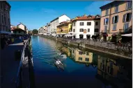  ?? (AP/Luca Bruno) ?? A kayaker glides along the Naviglio Grande canal Friday in Milan.