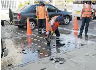  ??  ?? Operarios retiran reductores de velocidad en la carrera.