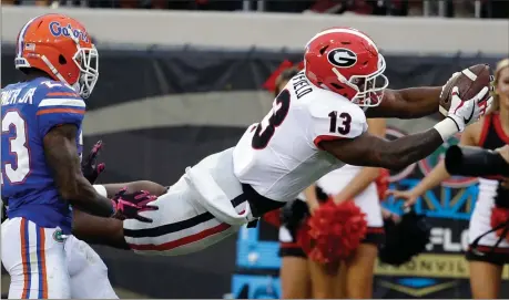  ?? File, John Raoux / The Associated Press ?? Georgia running back Elijah Holyfield (13) dives over the goal line in front of Florida defensive back Chauncey Gardner Jr. in Jacksonvil­le, Fla.