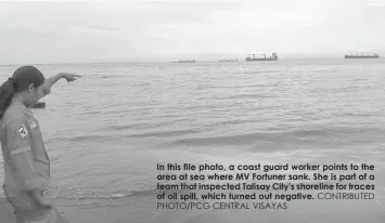  ?? PHOTO/PCG CENTRAL VISAYAS
CONTRIBUTE­D ?? IN THIS fiLE PHOTO, A COAST GUARD WORKER POINTS TO THE AREA AT SEA WHERE MV FORTUNER SANK. SHE IS PART OF A TEAM THAT INSPECTED TALISAY CITY'S SHORELINE FOR TRACES OF OIL SPILL, WHICH TURNED OUT NEGATIVE.