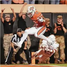  ?? Brody Schmidt / Associated Press ?? Oklahoma State wide receiver Tylan Wallace (2) jumps across the goal line for a second-quarter score Saturday night.